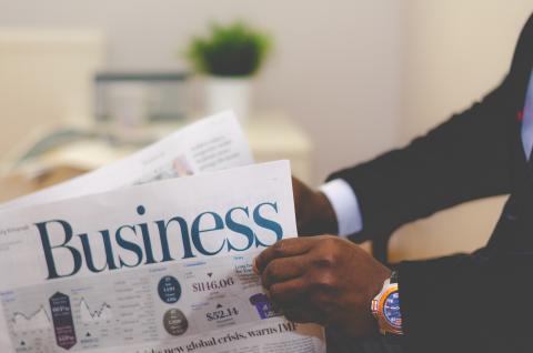 African American business man holding a business newspaper